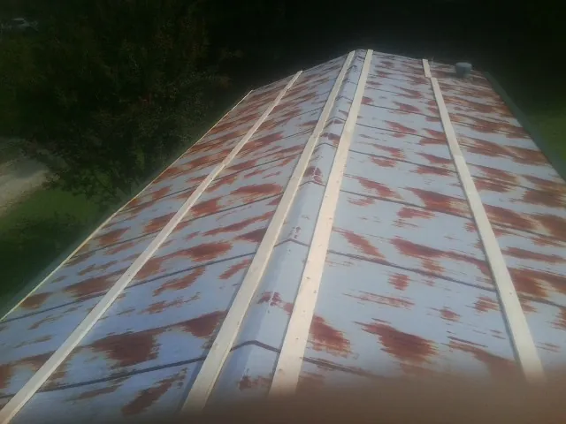 Rusted metal roof panels with new wood purlins before replacement — Storm Damage Roof Repair in Springport by Roofing Brothers