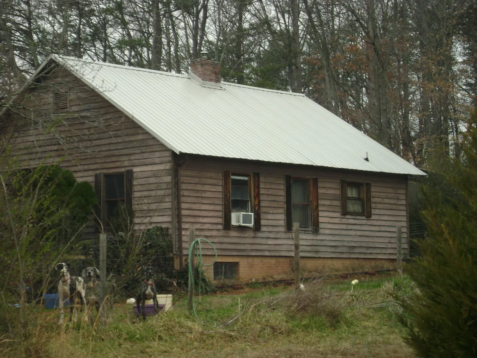 White metal roof on an old wood sided farmhouse, from a Metal Roof Installation job in Springport